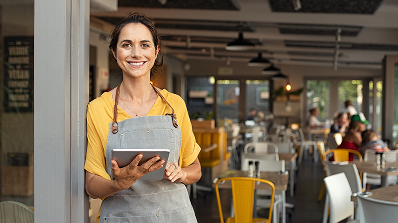 lady in front of her store holding a tablet