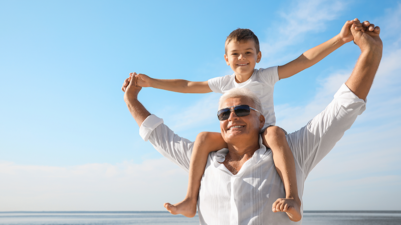 Grandfather carrying his grandchild on his shoulders