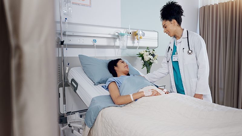 doctor talking to patient in their bed