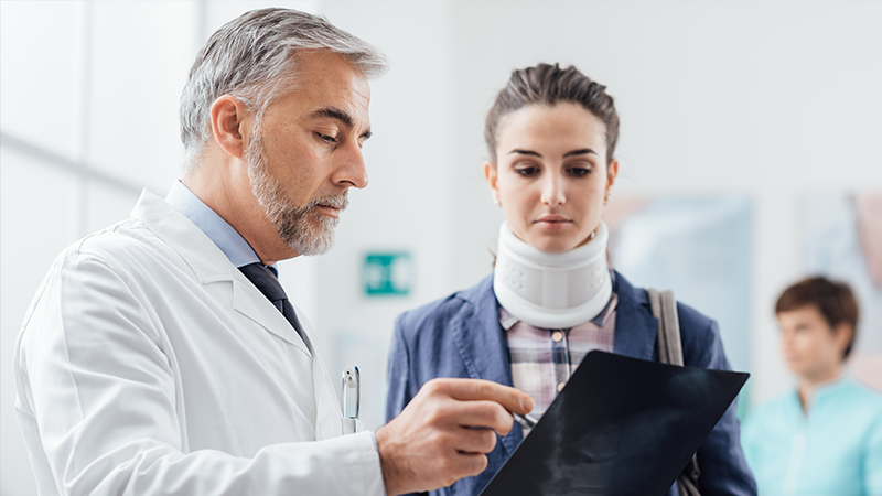 woman with neck injury talking to doctor